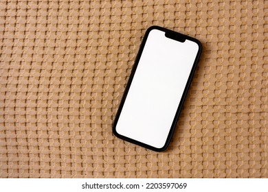 Top Down Mockup Image Of Smartphone With Blank White Touch Screen On Bed Linen