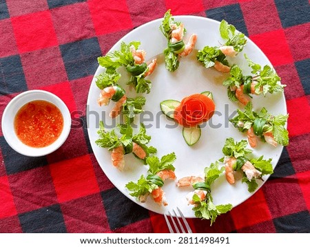 A top down perspective of a Tam Huu plate garnished with an artistic tomato flower. This stock usage image showcases the freshness of ingredients sourced from Tra Que village.