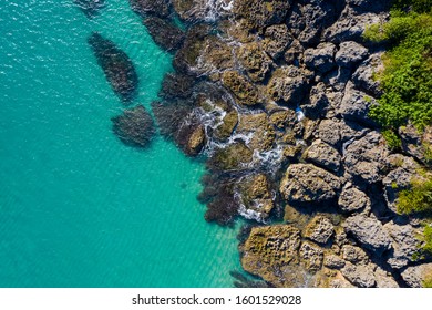 Top down Reef beach drone shot rocky coral reef crystal clear blue water ocean sea