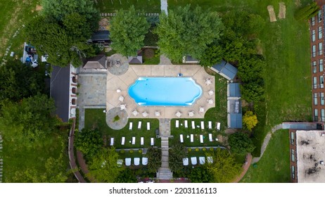 A Top Down Shot Directly Above An Empty Pool, Surrounded By Green Grass And Trees On A Cloudy Day. Taken Over A Mansion On Long Island, NY. The Shot Was Taken With A Drone Camera.