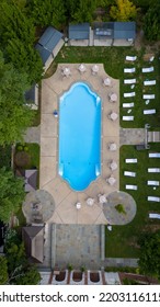 A Top Down Shot Directly Above An Empty Pool, Surrounded By Green Grass And Trees On A Cloudy Day. Taken Over A Mansion On Long Island, NY. The Shot Was Taken With A Drone Camera.