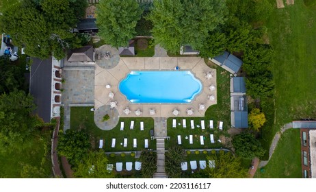 A Top Down Shot Directly Above An Empty Pool, Surrounded By Green Grass And Trees On A Cloudy Day. Taken Over A Mansion On Long Island, NY. The Shot Was Taken With A Drone Camera.