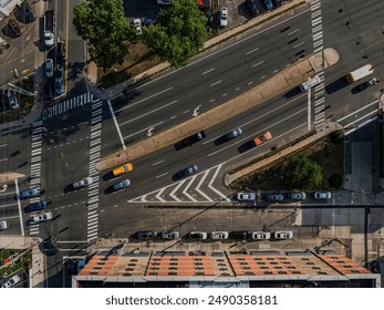 A top down shot over a multi-lane highway on a sunny day on Long Island, NY. Flying high over an apartment building we see a few vehicles driving by below.
