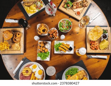 top down shot of round dinner table fully set with meals and drinks - Powered by Shutterstock