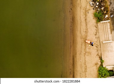 A Top Down Shot Taken Directly Over A Woman Who Was Preparing To Take Out Her Kayak. It Is A Cloudy Morning On The Shore Of The Hudson River In Upstate New York.