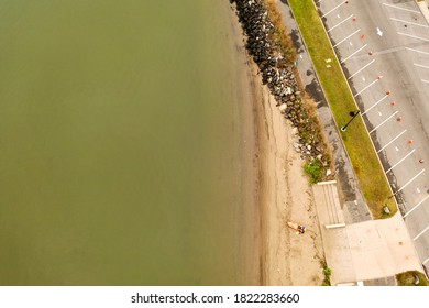 A Top Down Shot Taken Directly Over A Single Kayak. It Is A Cloudy Morning On The Shore Of The Hudson River In Upstate New York. There Is Also An Empty Parking Lot On The Right Of The Shot.