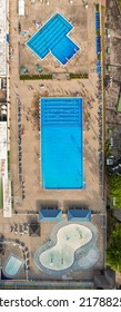 A Top Down Shot, Taken Directly Over Two Pools. There Are People In View And It Looks Like One Pool Is Opened For A Competition. The Picture Was Taken, Using A Drone Camera.