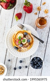 Top Down Vertical View Of A Stack Of Buttermilk Pancakes Served With Fresh Berries And Syrup, Ready For Eating.