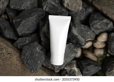 Top Down View Above Facial Skincare White Tube Product Blank Label On Crushed Dark Grey Stone Charcoal Color Or Road Metal Rough Texture Background