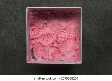 Top Down View Above Sweet Strawberry Pink Ice Cream Made From Real Fruit In White Paper Square Box Container With Dark Grey Or Black Stone Concrete Texture Background