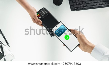 Top Down View Of An Anonymous Customer Paying With Contactless NFC Technology For Products Or Services In The Business Office, Over The Desk With Computer Keyboard And Mouse. Online Banking Concept.