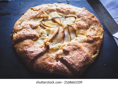 Top Down View Of An Apple Galette With A Spatula Lit By Natural Light