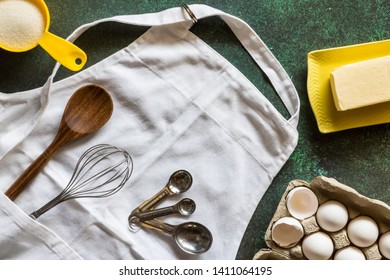 Top Down View Of An Apron With Cooking Utensils And Ingredients. Baking Concept.