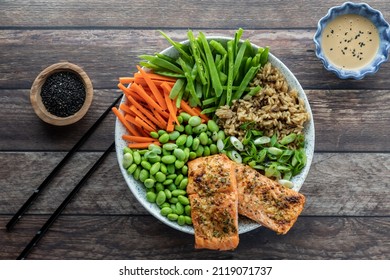 Top Down View Of An Asian Salmon Salad Bowl With Dressing And Black Sesame Seeds