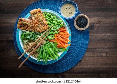 Top Down View Of An Asian Salmon Salad Bowl With Sesame Seeds And Dressing.