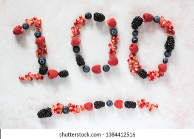 Top down view of berries in the shape of 100. Number concept.