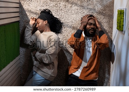 Top down view of black couple fighting on the floor at home, partners in a heated argument frustrated about each other, serious dispute and unhappy relationship due to enraged people.