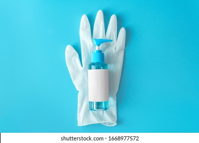 Top down view blue alcohol liquid for medical purpose and Anti coronavirus COVID-19 (Ethanol or ethyl alcohol) in a plastic press pump head blue bottle with blank label on white disposable glove.  - Shutterstock ID 1668977572