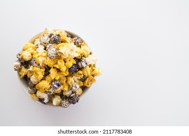 Top Down View Of A Bowl Of Colorful Popcorn Isolated Against A White Background With Copy Space.