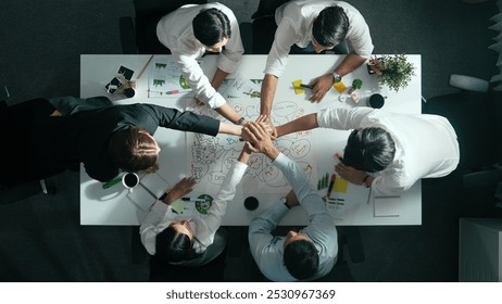 Top down view of business team discussing about using clean energy and sustainable investment at meeting table with wind mill, document with environmental graph and wooden house model. Alimentation. - Powered by Shutterstock