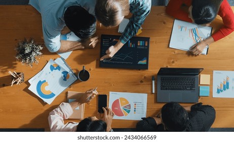 Top down view of business woman explain and present financial chart. Diverse group discuss and listen presentation about stock market statistic at meeting table with investment graph. Convocation. - Powered by Shutterstock