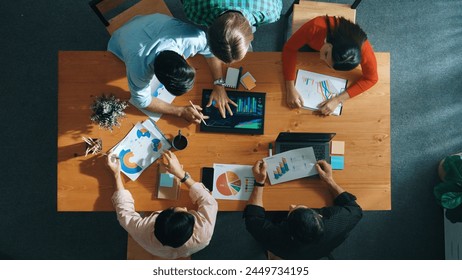 Top down view of business woman explain and present financial chart. Diverse group discuss and listen presentation about stock market statistic at meeting table with investment graph. Convocation. - Powered by Shutterstock