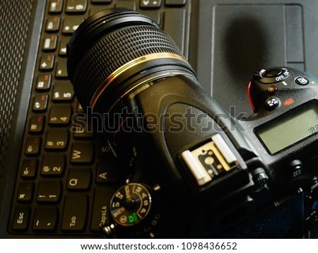 Top down view of a Camera and a laptop computer. Basic requirements for stock photography business.          