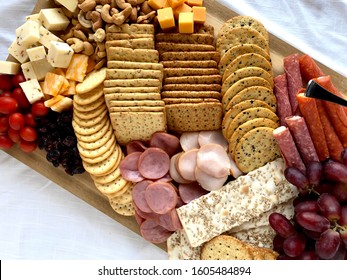 Top Down View Of A Charcuterie Board With Assorted Crackers, Meats And Cheeses