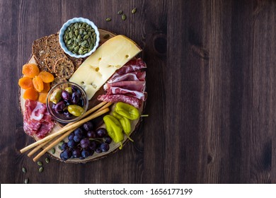 Top Down View Of A Charcuterie Board Filled With Various Finger Foods.