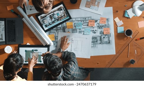 Top down view of civil engineer handed document while looking at blueprint. Aerial view of architect team brainstorming idea and planning building design while sitting at table with plan. Symposium. - Powered by Shutterstock