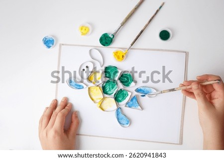 top down view of close up of hands painting activity, toilet paper roll rings turtle art idea, funny craft and DIY project for parents with children 