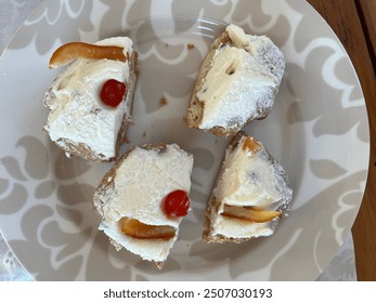 Top down view, close up of one St. Joseph's Day pastry, or Italian Zeppole Di San Guiseppe that has been cut into four pieces.