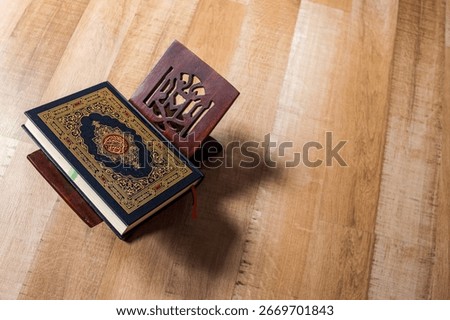 Top Down View Of Closed Qur'an Resting On Traditional Wooden Stand On Hardwood Floor
