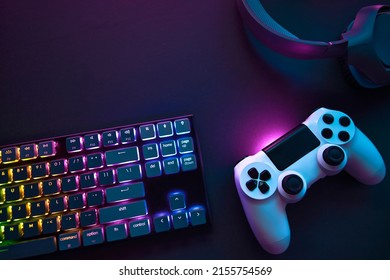 Top down view of colorful illuminated gaming accessories laying on table. Professional computer game playing, esport business and online world concept. - Powered by Shutterstock