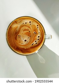 Top Down View Of Cup Of Cappuccino In The Sunlight On The White Background