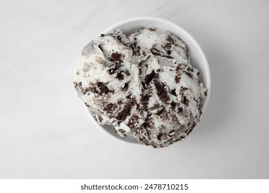 A top down view of a cup with two scoops of cookies and cream ice cream.