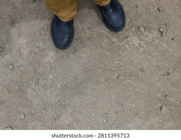 Top Down View of Dark Black Loafers on Dusty Textured Dirt Ground