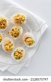 Top Down View Of Deviled Eggs Topped With Paprika And Chives.