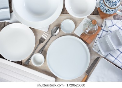 A top down view of a dining table place setting, featuring an array of clean empty dinnerware.