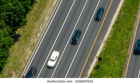 A Top Down View Directly Above A Quiet Highway On A Sunny Day With Green Trees And Grass In View. Taken By A Drone Camera Showing The Beautiful Long Island Landscape.