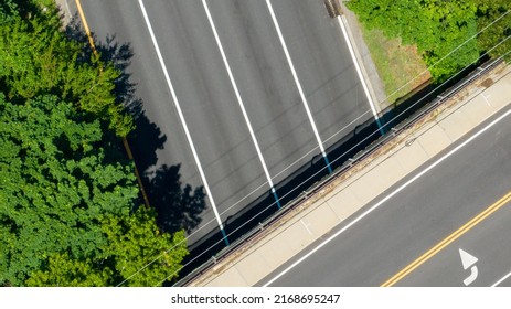 A Top Down View Directly Above A Quiet Highway On A Sunny Day With Green Trees And Grass In View. Taken By A Drone Camera Showing The Beautiful Long Island Landscape.