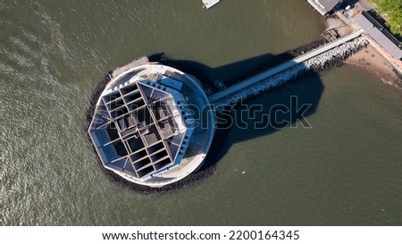 
A top down view directly above the Brooklyn Battery Tunnel ventilation tower off of Governors Island in New York City on a sunny day.