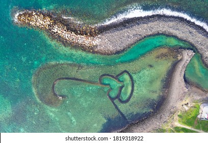 Top down view of the Double-Heart of Stacked Stones or the Twin-Heart Fish Trap bathed in the beautiful sea water, which is a fishing weir and now a popular tourist attraction in Cimei, Penghu, Taiwan