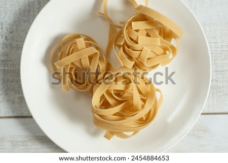 A top down view of dry bundles gluten-free tagliatelle pasta.
