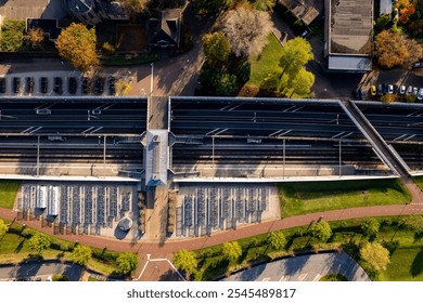 Top down view of Dutch railway train station and provincial road coming through countryside landscape tunnel and viaduct seen from above. Aerial public transportation. Parking lot bicycle stalls. - Powered by Shutterstock