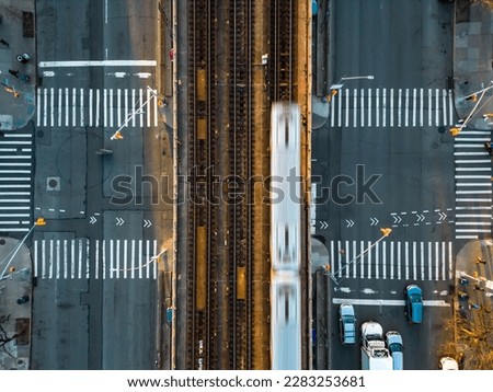 A top down view of the Flushing Line of the New York City Subway train tracks that run down the center of Queens Boulevard. Taken during sunset.