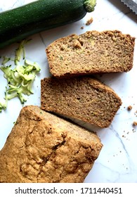 Top down view of freshly baked and sliced zucchini bread on a white granite background