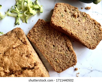 Top down view of freshly baked and sliced zucchini bread on a white granite background