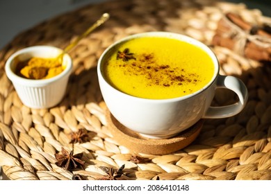 Top Down View Of Golden Milk Or Turmeric Latte Cup On A Straw Plate Stand.