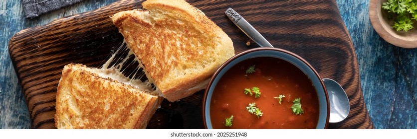 Top Down View Of A Grilled Cheese Sandwich Served With A Bowl Of Tomato Soup, Ready For Eating.